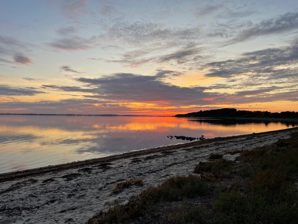 Smuk solnedgang over stille strand i Danmark